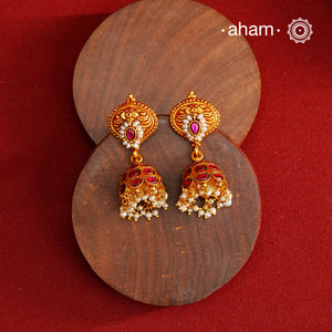 Traditional jhumkies showcasing exquisite Kemp work, meticulously crafted in 92.5% silver with a fine gold polish finish. Adorned with delicate pearls, they blend classic elegance with expert craftsmanship, making them a timeless addition to any jewelry collection.