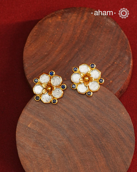 Crafted in 92.5% sterling silver with a refined gold polish, these petite flower studs feature intricate kundan detailing accented by blue stone highlights. Their elegant design blends traditional artistry with modern sophistication, making them an ideal accessory for both everyday wear and special occasions.