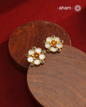Crafted in 92.5% sterling silver with a refined gold polish, these petite flower studs feature intricate kundan detailing accented by blue stone highlights. Their elegant design blends traditional artistry with modern sophistication, making them an ideal accessory for both everyday wear and special occasions.