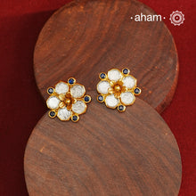 Crafted in 92.5% sterling silver with a refined gold polish, these petite flower studs feature intricate kundan detailing accented by blue stone highlights. Their elegant design blends traditional artistry with modern sophistication, making them an ideal accessory for both everyday wear and special occasions.