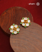 Crafted in 92.5% sterling silver with a refined gold polish, these petite flower studs feature intricate kundan detailing accented by vibrant green stones. Their elegant design blends traditional artistry with modern sophistication, making them an ideal accessory for both everyday wear and special occasions.
