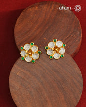 Crafted in 92.5% sterling silver with a refined gold polish, these petite flower studs feature intricate kundan detailing accented by vibrant green stones. Their elegant design blends traditional artistry with modern sophistication, making them an ideal accessory for both everyday wear and special occasions.