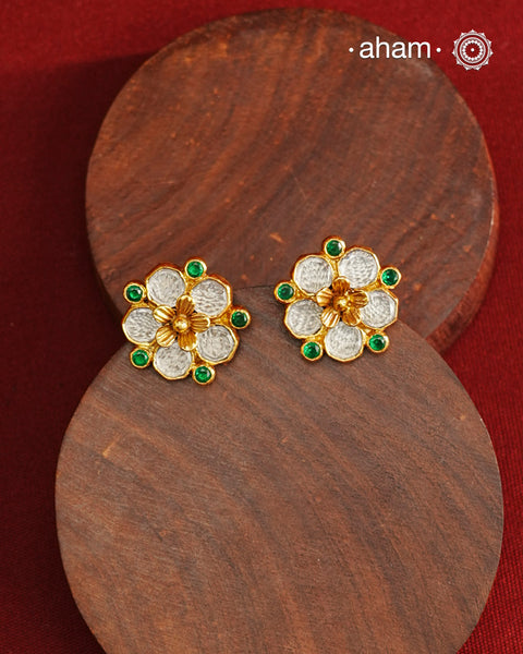 Crafted in 92.5% sterling silver with a refined gold polish, these petite flower studs feature intricate kundan detailing accented by vibrant green stones. Their elegant design blends traditional artistry with modern sophistication, making them an ideal accessory for both everyday wear and special occasions.