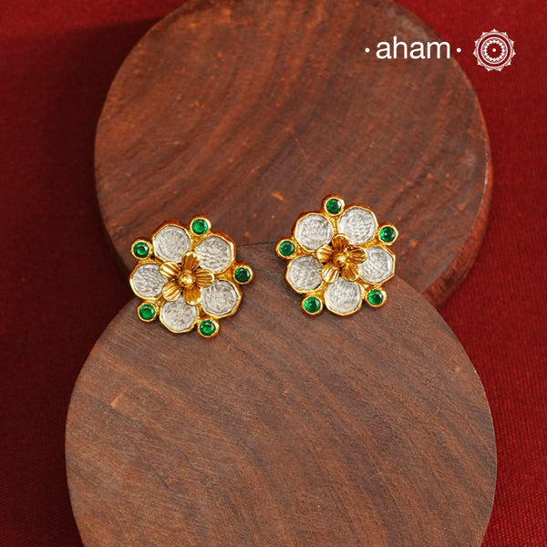 Crafted in 92.5% sterling silver with a refined gold polish, these petite flower studs feature intricate kundan detailing accented by vibrant green stones. Their elegant design blends traditional artistry with modern sophistication, making them an ideal accessory for both everyday wear and special occasions.