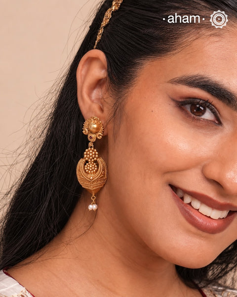 Statement gold polish earring with beautiful designs inspired from the temples of South India. Handcrafted using traditional methods in 92.5 sterling silver with dull gold polish.Pair these with your ethnic outfits this festive season to ace your look.