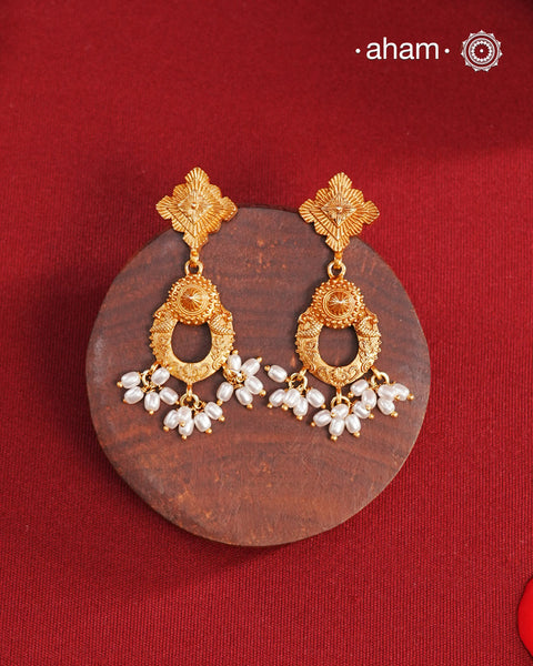 Statement gold polish earring with beautiful designs inspired from the temples of South India. Handcrafted using traditional methods in 92.5 sterling silver with dull gold polish. Pair these with your ethnic outfits this festive season to ace your look.