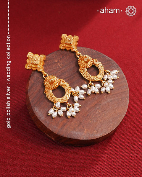 Statement gold polish earring with beautiful designs inspired from the temples of South India. Handcrafted using traditional methods in 92.5 sterling silver with dull gold polish. Pair these with your ethnic outfits this festive season to ace your look.