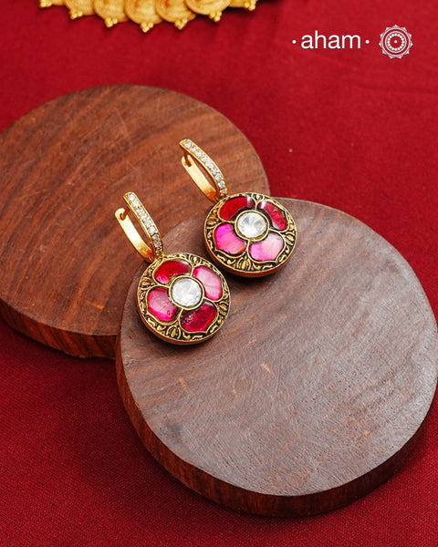 These two-sided hoop earrings combine classic elegance with contemporary design. Made from 92.5% silver and finished with a fine gold polish, they showcase red kundan stones on one side and green kundan on the other. This dual-sided feature offers versatile styling options, complementing a wide range of Indian attire. Expertly crafted, these earrings deliver both quality and adaptability for sophisticated everyday or festive wear.