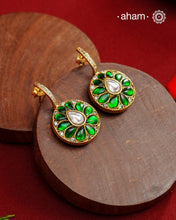 These&nbsp; hoop inspired earrings combine classic elegance with contemporary design. Made from 92.5% silver and finished with a fine gold polish, they showcase greenkundan stones on one side and red kundan on the back. Expertly crafted, these earrings deliver both quality and adaptability for most Indian attires.