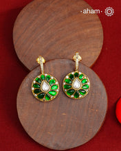 These&nbsp; hoop inspired earrings combine classic elegance with contemporary design. Made from 92.5% silver and finished with a fine gold polish, they showcase greenkundan stones on one side and red kundan on the back. Expertly crafted, these earrings deliver both quality and adaptability for most Indian attires.