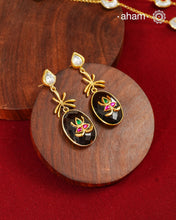 These Black Onyx Gold Polish Silver Earrings feature exquisite kundan inlay work, blending traditional craftsmanship with contemporary style. Perfectly suited for Indo-Western ensembles, they add a touch of elegance and sophistication to your look. Crafted with attention to detail, these earrings enhance your outfit with their rich black onyx contrast and subtle gold polish, making them a versatile accessory for special occasions.