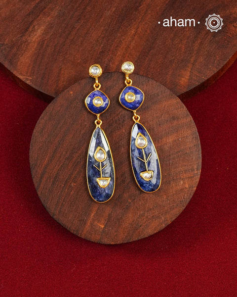 These Lapiz Gold Polish Silver Earrings feature exquisite kundan inlay work, blending traditional craftsmanship with contemporary style. Perfectly suited for Indo-Western ensembles, they add a touch of elegance and sophistication to your look. Crafted with attention to detail, these earrings enhance your outfit with their deep blue contrast and subtle gold polish, making them a versatile accessory for special occasions.