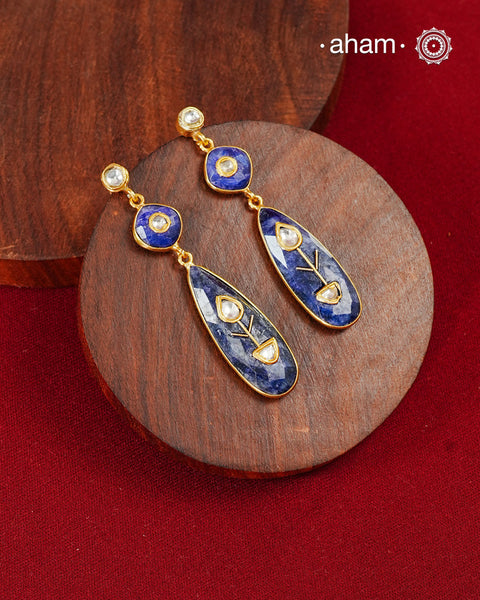 These Lapiz Gold Polish Silver Earrings feature exquisite kundan inlay work, blending traditional craftsmanship with contemporary style. Perfectly suited for Indo-Western ensembles, they add a touch of elegance and sophistication to your look. Crafted with attention to detail, these earrings enhance your outfit with their deep blue contrast and subtle gold polish, making them a versatile accessory for special occasions.