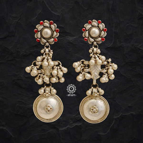 Tribal fish earrings created in silver with traditional artistry and craftsmanship. With a beautiful rose stud, red glass stone highlights and statement ghungroos.