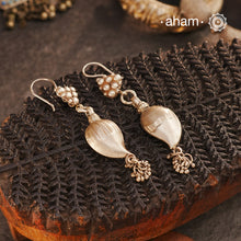 Celebrate timeless tradition with our Tribal Ambi Silver Earrings, featuring a striking Ambi (Mango) bead adorned with delicate ghungroos at the bottom. The top showcases&nbsp;stamp work flower, a hallmark of tribal craftsmanship from India. Handcrafted in&nbsp;silver, these earrings embody the beauty of vintage tribal jewellery — perfect for those seeking a blend of heritage and charm.