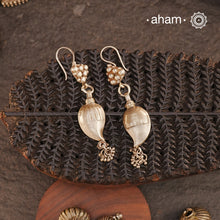 Celebrate timeless tradition with our Tribal Ambi Silver Earrings, featuring a striking Ambi (Mango) bead adorned with delicate ghungroos at the bottom. The top showcases&nbsp;stamp work flower, a hallmark of tribal craftsmanship from India. Handcrafted in&nbsp;silver, these earrings embody the beauty of vintage tribal jewellery — perfect for those seeking a blend of heritage and charm.