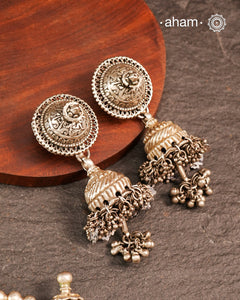 Elevate your festive look with this striking Tribal Silver Jhumkie, featuring bold, layered ghungroos that create a captivating sound and movement. Expertly crafted in silver, this statement earring complements all ethnic wear, making it perfect for Navratri and other celebrations. Its impressive size and intricate design add a traditional yet contemporary touch to your ensemble.