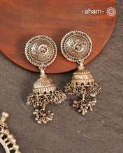 Elevate your festive look with this striking Tribal Silver Jhumkie, featuring bold, layered ghungroos that create a captivating sound and movement. Expertly crafted in silver, this statement earring complements all ethnic wear, making it perfect for Navratri and other celebrations. Its impressive size and intricate design add a traditional yet contemporary touch to your ensemble.