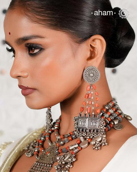 Large statement Chandelier earrings crafted in silver. Inspired from tribal forms, we have added turquoise and pearls to create drama to the whole piece. The fine rawa work and multiple ghungroos at the bottom add charm to the piece.