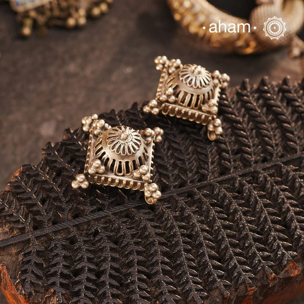 Crafted in silver with a unique jali-like pattern and rava highlights, these Tribal Silver Studs combine traditional tribal inspiration with modern elegance. Perfect for adding a touch of culture to any outfit.