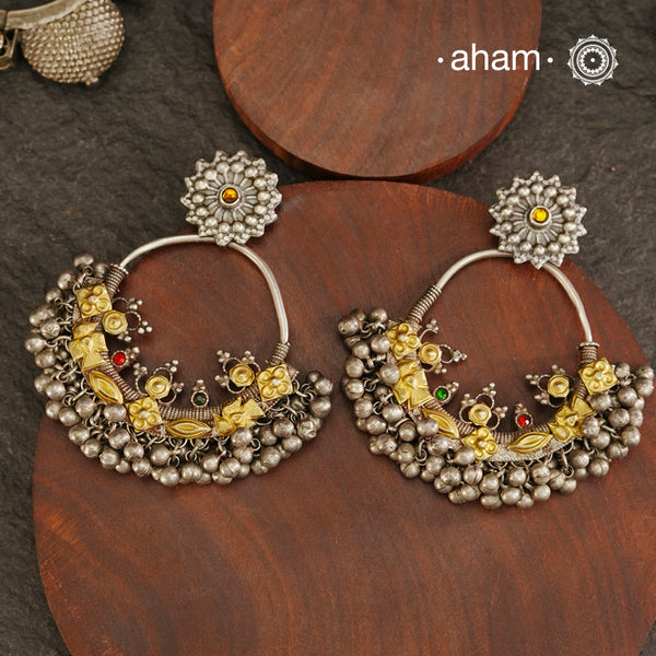A classic design from Rajasthan's tribal heritage, these Tribal Silver Bali Earrings feature a delicate curve adorned with red and green stones and a cluster of ghungroos at the bottom, adding rhythm and movement. We have added a stud on the top for ease of wear. Handcrafted in silver, these balis perfectly capture the essence of traditional tribal jewellery. Please note the earrings are slightly heavy.