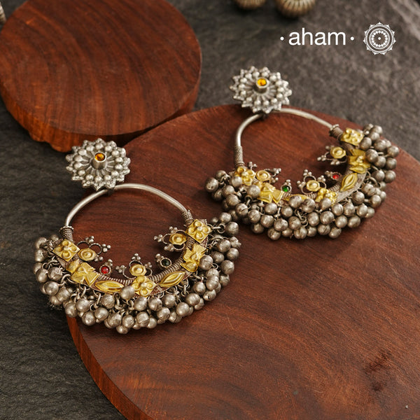 A classic design from Rajasthan's tribal heritage, these Tribal Silver Bali Earrings feature a delicate curve adorned with red and green stones and a cluster of ghungroos at the bottom, adding rhythm and movement. We have added a stud on the top for ease of wear. Handcrafted in silver, these balis perfectly capture the essence of traditional tribal jewellery. Please note the earrings are slightly heavy.