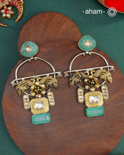 Statement Noori two tone earrings with green semi precious stone setting. Handcrafted in 92.5 sterling silver with elegant peacock motif.&nbsp;Style this up with your favourite ethnic or fusion outfits to complete the look.