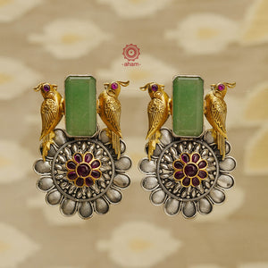 Experience the perfect blend of elegance and style with our Noori Two Tone Silver Earrings. Handcrafted in 92.5 sterling silver, these earrings feature a stunning flower motif and two delicate cockatoo birds, adorned with a vibrant green stone. Elevate any ethnic or fusion outfit with this unique accessory.