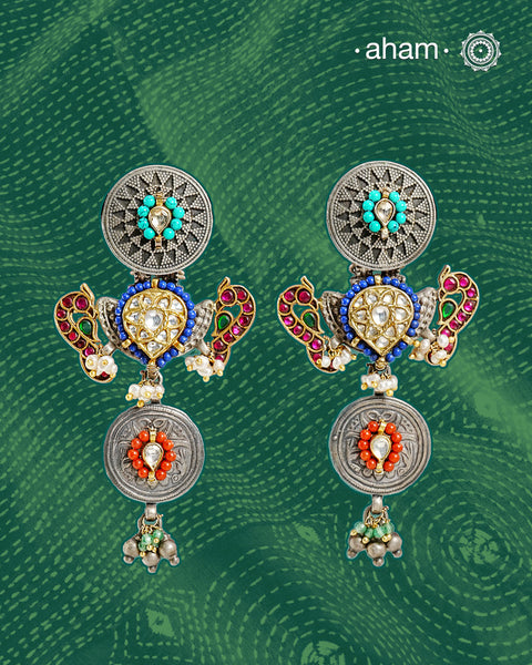 Noori statement silver two tone earrings with shades of silver and gold. One of a kind piece, handcrafted with beautiful bird motif and semi precious stones. Style this up with your favourite ethnic or fusion outfit.