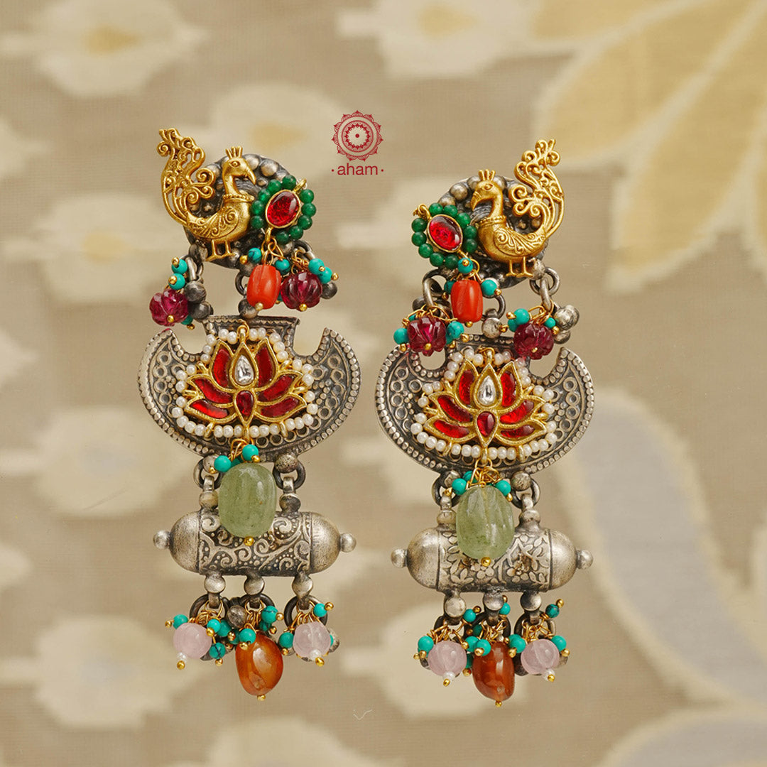 Noori two tone handcrafted earrings in 92.5 sterling silver with dual tones. Eclectic mix of elements with beautiful peacock & lotus motifs, pearls and semi precious stones. Style this up with your favourite ethnic or fusion outfit.