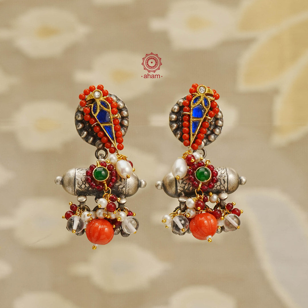 Noori two tone earrings in 92.5 sterling silver with gold highlights. Handcrafted earrings with beautiful coral coloured bead highlights. Style this up with your favourite ethnic or fusion outfit.