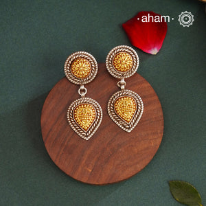 Enhance your style with the timeless elegance of the Dual Tone Silver Earrings. Handcrafted by skilled karigars in Barmer, Rajasthan, this earring features traditional Bandhel work, where a thin sheet of hand beaten 22 carat gold is set on 92.5 silver using a unique wax filling technique. A classic representation of Indian craftsmanship.