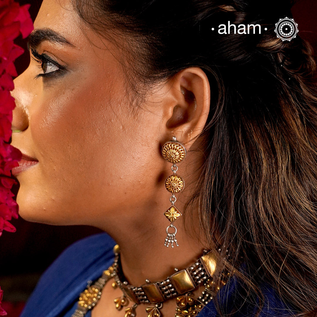 Enhance your style with the timeless elegance of the Dual Tone Silver Earrings. Handcrafted by skilled karigars in Barmer, Rajasthan, this earring features traditional Bandhel work, where a thin sheet of hand beaten 22 carat gold is set on 92.5 silver using a unique wax filling technique. A classic representation of Indian craftsmanship.