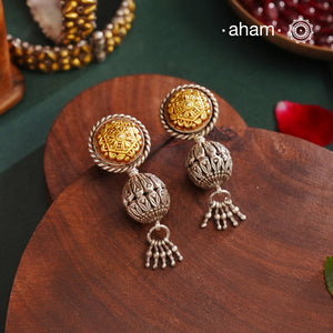 Enhance your style with the timeless elegance of the Dual Tone Silver Earrings. Handcrafted by skilled karigars in Barmer, Rajasthan, this earring features traditional Bandhel work, where a thin sheet of hand beaten 22 carat gold is set on 92.5 silver using a unique wax filling technique. A classic representation of Indian craftsmanship.