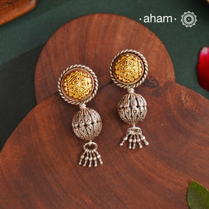 Enhance your style with the timeless elegance of the Dual Tone Silver Earrings. Handcrafted by skilled karigars in Barmer, Rajasthan, this earring features traditional Bandhel work, where a thin sheet of hand beaten 22 carat gold is set on 92.5 silver using a unique wax filling technique. A classic representation of Indian craftsmanship.