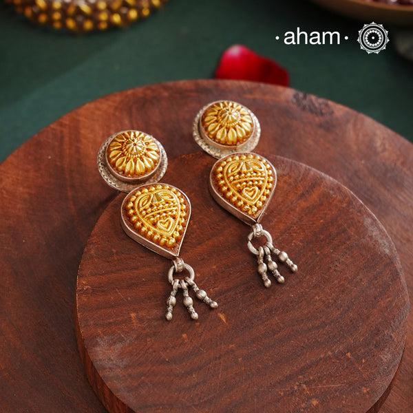 Enhance your style with the timeless elegance of the Dual Tone Silver Earrings. Handcrafted by skilled karigars in Barmer, Rajasthan, this earring features traditional Bandhel work, where a thin sheet of hand beaten 22 carat gold is set on 92.5 silver using a unique wax filling technique. A classic representation of Indian craftsmanship.