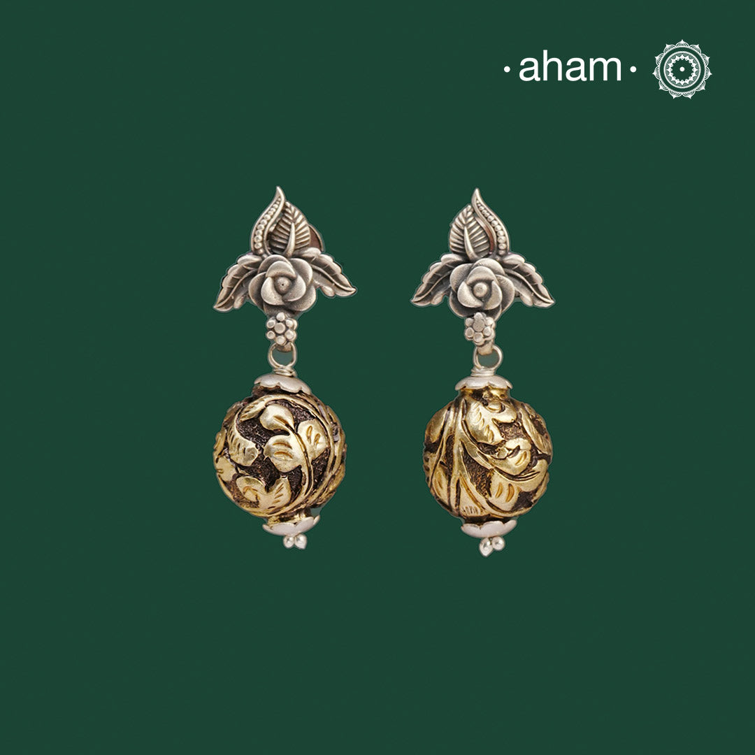 Expertly handcrafted with 92.5 silver, these dual tone earrings are both versatile and easy to wear. They come with a flower motif on the top and chitai ball drops. Perfect for any occasion, whether it be a day at the office or a casual evening out. Elevate your style with these Noori Two Tone Silver Earrings.