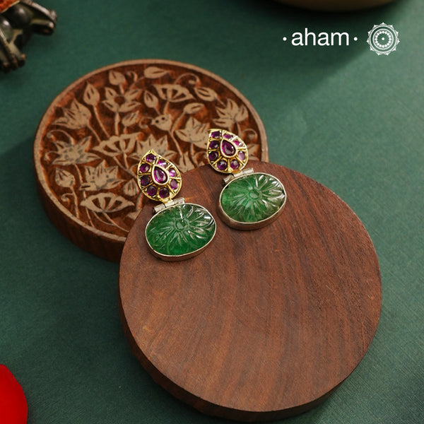 These Noori Two Tone Silver Earrings are expertly handcrafted from 92.5 sterling silver, showcasing traditional South Indian artistry. Featuring a delicately carved green stone, they add a refined touch to both ethnic and fusion ensembles. Perfect for elevating your look with authentic craftsmanship and timeless elegance.