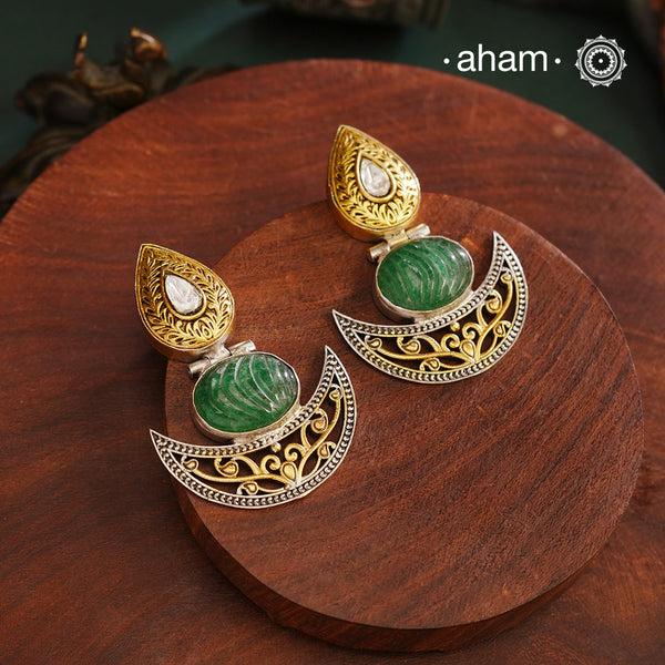 Noori Two Tone Diya Silver Earrings. The earrings are handcrafted in 92.5 sterling silver with beautiful green carved stone center and gold highlights. Style this up with your favourite ethnic or fusion outfits to complete the look.