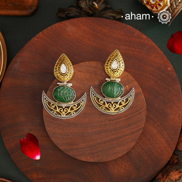 Noori Two Tone Diya Silver Earrings. The earrings are handcrafted in 92.5 sterling silver with beautiful green carved stone center and gold highlights. Style this up with your favourite ethnic or fusion outfits to complete the look.