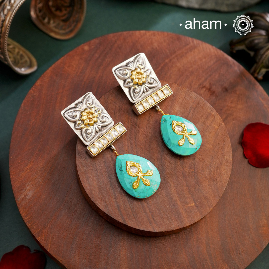 Experience elegance and beauty with our Noori Two Tone Silver Earrings! These stunning dual tone earrings feature a striking turquoise drop with intricate inlay work and kundan highlights. Elevate your style and make a statement with these exquisite earrings.