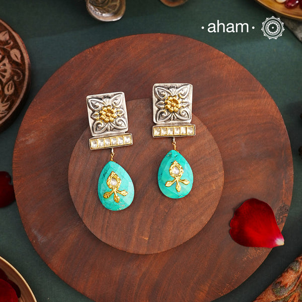 Experience elegance and beauty with our Noori Two Tone Silver Earrings! These stunning dual tone earrings feature a striking turquoise drop with intricate inlay work and kundan highlights. Elevate your style and make a statement with these exquisite earrings.