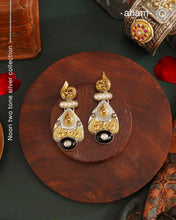 Noori two tone Earrings. The earrings are handcrafted in 92.5 sterling silver with gold highlights comes with a intricately carved peacock on the top and black onyx highlight. Style this up with your favourite ethnic or fusion outfits to complete the look.