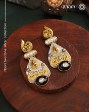 Noori two tone Earrings. The earrings are handcrafted in 92.5 sterling silver with gold highlights comes with a intricately carved peacock on the top and black onyx highlight. Style this up with your favourite ethnic or fusion outfits to complete the look.
