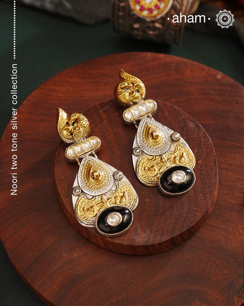 Noori two tone Earrings. The earrings are handcrafted in 92.5 sterling silver with gold highlights comes with a intricately carved peacock on the top and black onyx highlight. Style this up with your favourite ethnic or fusion outfits to complete the look.