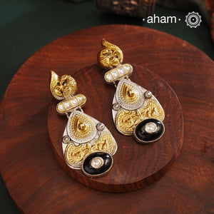 Noori two tone Earrings. The earrings are handcrafted in 92.5 sterling silver with gold highlights comes with a intricately carved peacock on the top and black onyx highlight. Style this up with your favourite ethnic or fusion outfits to complete the look.