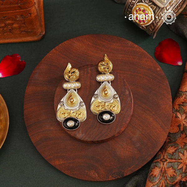 Noori two tone Earrings. The earrings are handcrafted in 92.5 sterling silver with gold highlights comes with a intricately carved peacock on the top and black onyx highlight. Style this up with your favourite ethnic or fusion outfits to complete the look.