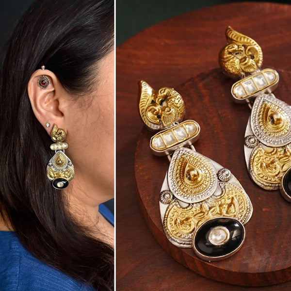 Noori two tone Earrings. The earrings are handcrafted in 92.5 sterling silver with gold highlights comes with a intricately carved peacock on the top and black onyx highlight. Style this up with your favourite ethnic or fusion outfits to complete the look.