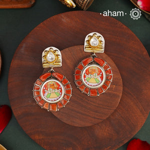 A beautiful earring featuring finely hand painted miniature Ganesha combined with coral ascents, The earrings are handcrafted in 92.5 sterling silver with gold highlights. Style this up with your favourite ethnic or fusion outfits to complete the look.