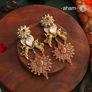 Enhance your look with our Noori Two Tone Silver Earrings! These elegant earrings feature a beautiful coral drop and faux polki in the center, embellished with intricate peacock designs on both sides. The two tone finish adds a touch of sophistication to any outfit. Elevate your style with these stunning earrings.